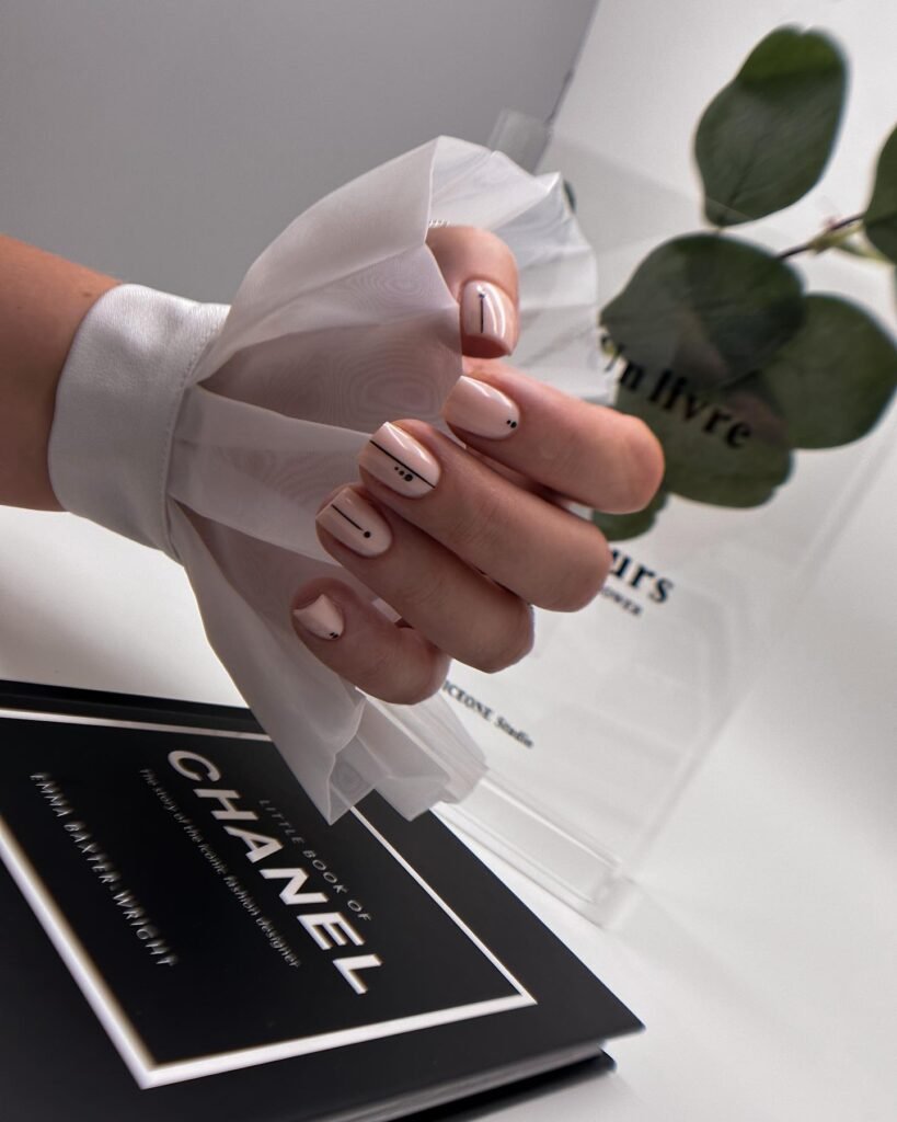 Sophisticated beige nails with minimalist black line and dot designs