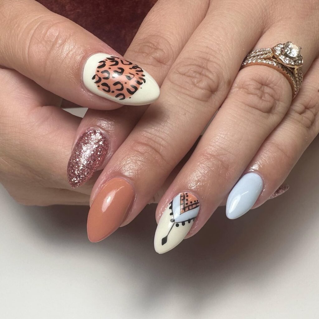 Close-up of glamorous nails with leopard print, glitter and western designs showing creative nashville nails ideas
