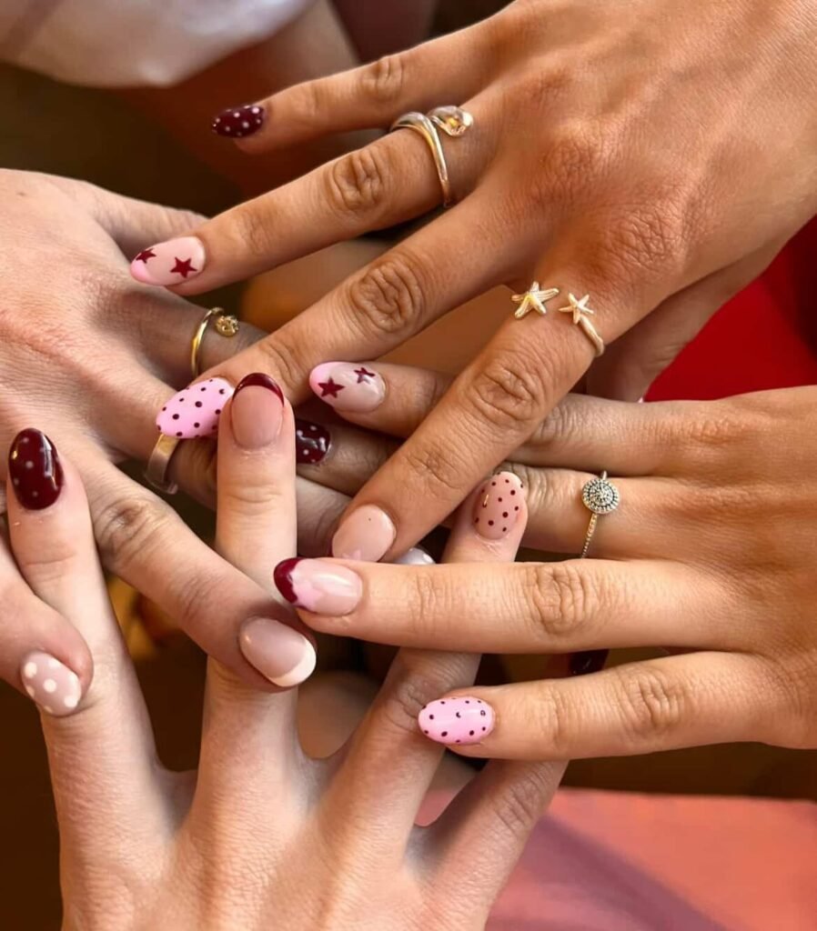Cute pink polka dot and red star best friend nails ideas on layered hands showing off matching friendship manicures