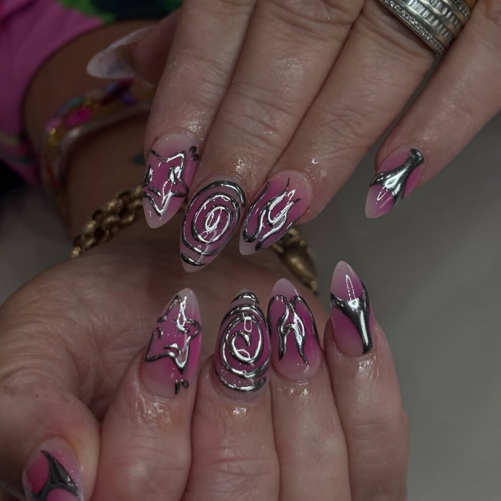 Gorgeous pink ombre nails with silver chrome stars, swirls and flames showcasing aesthetic nails ideas