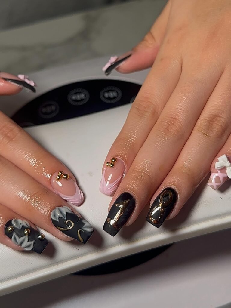 Stunning manicure showcasing elegant 18th birthday nails in black and pink with gold details and 3D flowers