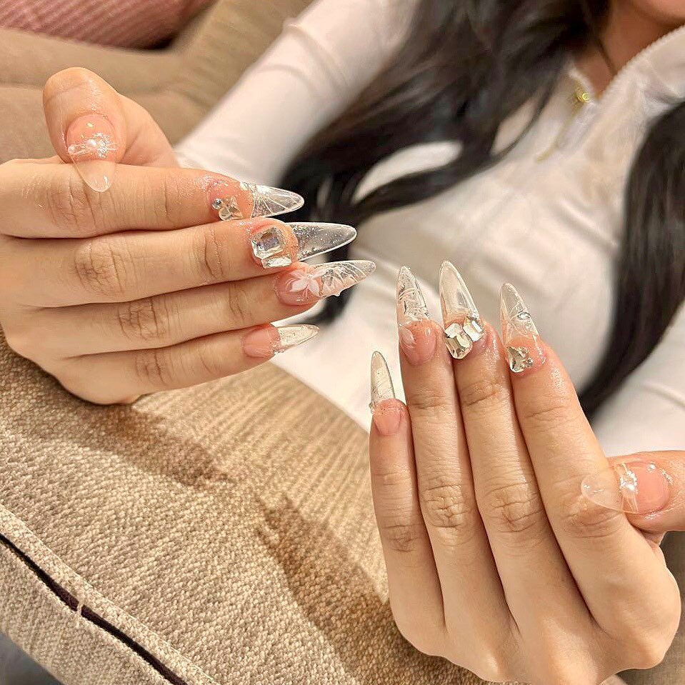 Whimsical clear nails ideas with 3D butterflies, crystals, and floral details for a magical manicure