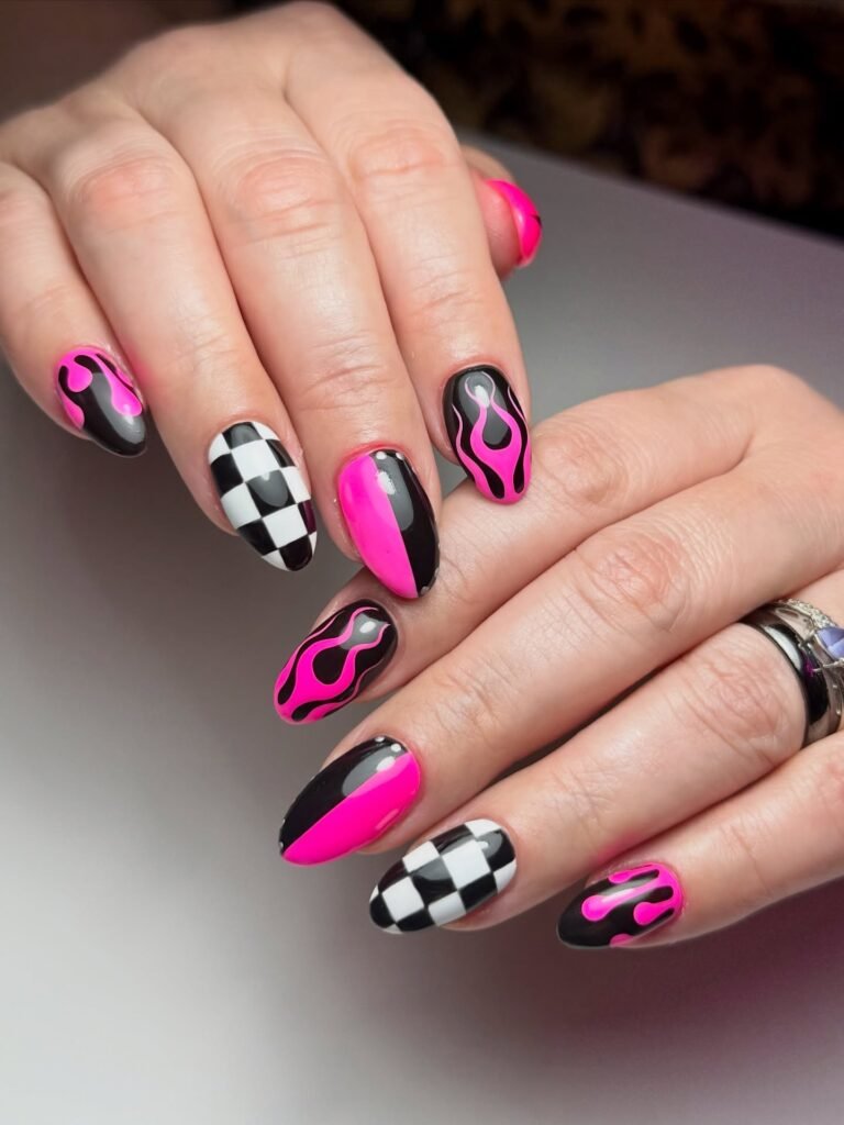 Check out these fiery emo nails ideas blending hot pink flames, black-and-white checkerboard patterns, and glossy split-color designs