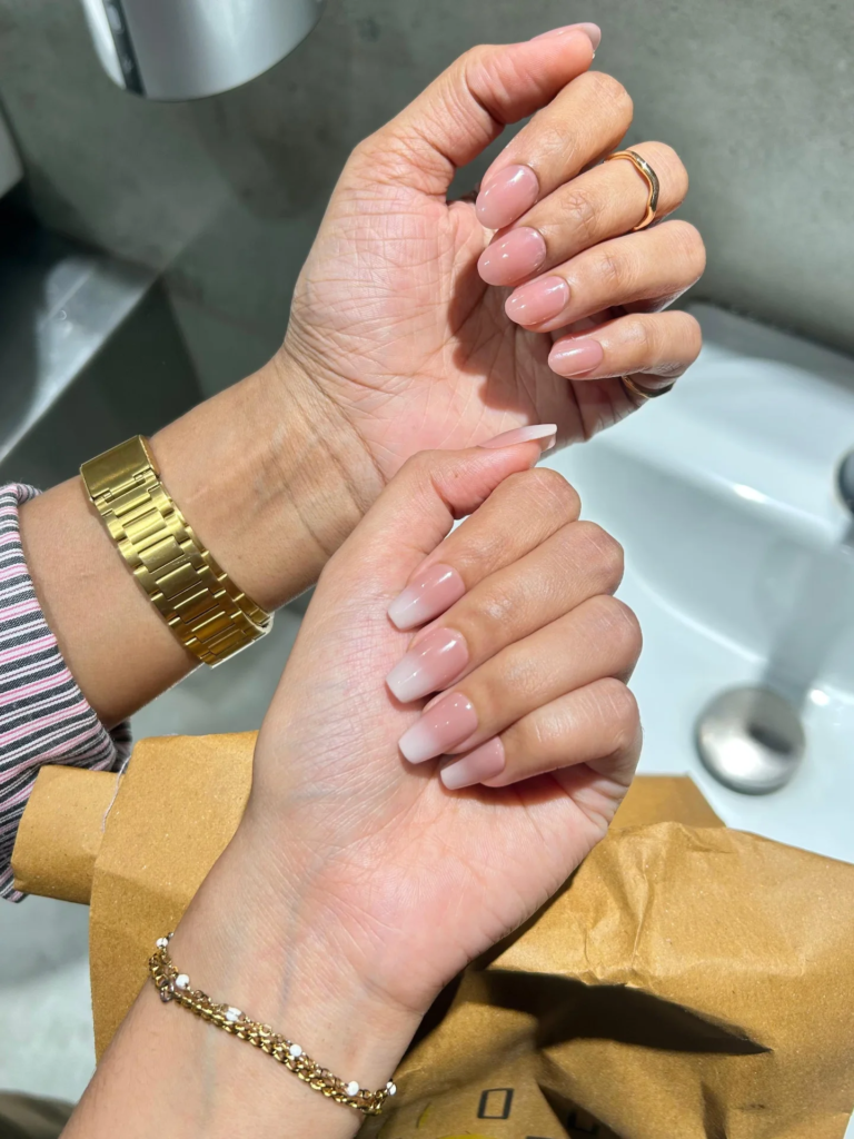 Elegant soft nude ombré senior nails ideas styled with gold watch and bracelet