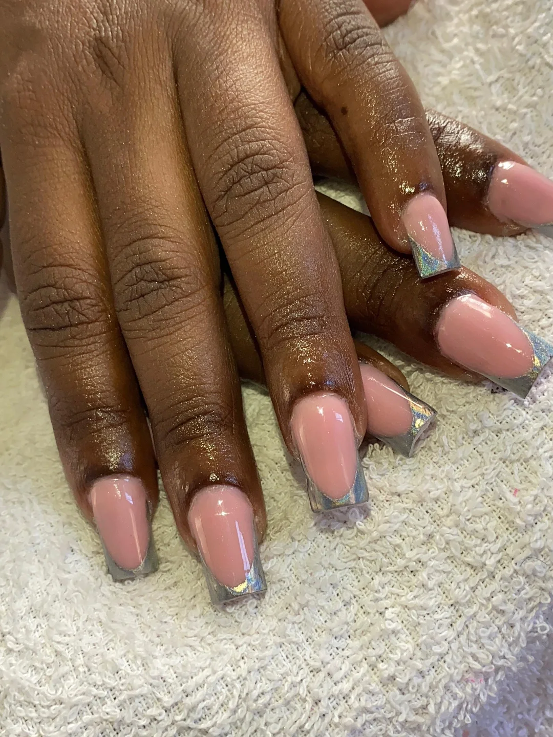 Natural nails painted with a simple silver french tip nails and subtle shimmer accent.